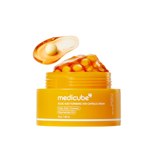 MEDICUBE Kojic Acid Turmeric Vita Capsule Cream is a brightening and revitalizing moisturizer designed to improve uneven skin tone and restore a healthy glow. Formulated with Kojic Acid, Turmeric Root Extract, and Niacinamide, it helps target dark spots while supporting a more balanced complexion. The capsule cream texture delivers active ingredients evenly into the skin, while Ceramides, Hyaluronic Acid, and Peptides help maintain hydration and strengthen the skin barrier. With added antioxidants and gentl