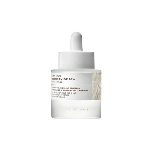 SKIN1004 Madagascar Centella Niacinamide 10 Boosting Shot Ampoule is a brightening serum that helps even out skin tone, reduce dark spots, and refine pores. It contains 10% Niacinamide along with Tranexamic Acid and Vitamin C to boost radiance and improve texture. The formula includes Hydrolyzed Sponge (Spicules) - microneedle-like natural structures that create tiny pathways in the skin to help active ingredients absorb better. Soothing ingredients like Centella Asiatica, Panthenol, and Madecassoside calm 
